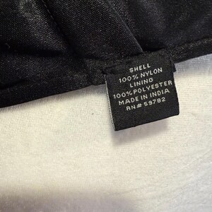 Pu&ograve; includere: Etichetta di cura del tessuto nera con testo bianco. Guscio: 100% Nylon. Fodera: 100% Poliestere. Prodotto in India. RN# 59782.