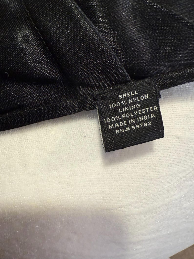 Pu&ograve; includere: Etichetta di cura del tessuto nera con testo bianco. Guscio: 100% Nylon. Fodera: 100% Poliestere. Prodotto in India. RN# 59782.