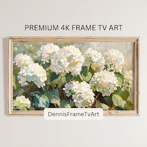 Op de afbeelding: Een ingelijst schilderij van witte hortensia's in een vaas. Het schilderij is in een licht houten lijst en heeft een witte achtergrond. De tekst "DennisFrameTvArt" staat onderaan het schilderij.