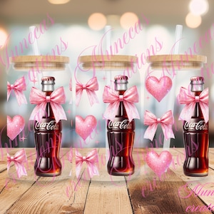 Puede incluir: Tres vasos de vidrio transparentes con tapas de bambú y lazos rosas y blancos. Cada vaso contiene una botella de Coca-Cola.