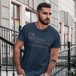 Op de afbeelding: Marineblauwe crew neck t-shirt met de tekst "I'M NOT FOR EVERYONE" in grijze blokletters. Het t-shirt is gemaakt van een zacht materiaal en is geschikt voor casual wear.