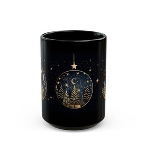 Könnte beinhalten: Schwarze Keramiktasse mit einem goldenen Design eines Nachthimmels mit Sternen, einer Mondsichel und einem Wald aus Bäumen in einem Kreis. Das Design wiederholt sich auf der Tasse.