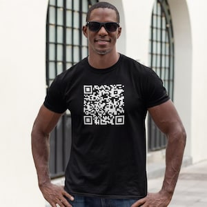 May include: A man wearing a black t-shirt with a white QR code printed on the front. The man is wearing sunglasses and has a light complexion.