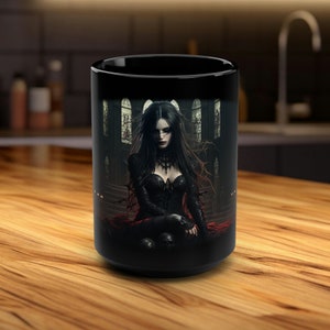 Könnte beinhalten: Schwarze Keramiktasse mit einem gotischen Design, das eine Frau in einem schwarzen Kleid und einem roten Umhang zeigt, die auf einem Thron in einer dunklen Kathedrale sitzt.