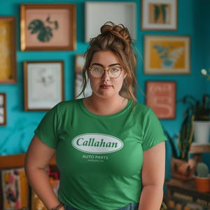 May include: A woman wearing a green t-shirt with a white oval logo that says "Callahan Auto Parts Sandusky OH".