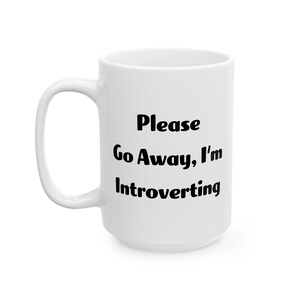 Pode incluir: Caneca de café de cerâmica branca com texto preto que diz "Please Go Away, I'm Introverting".