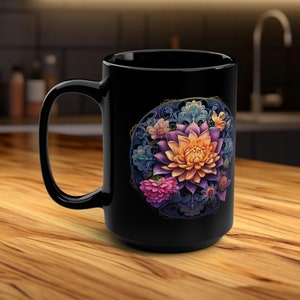 Könnte beinhalten: Schwarze Keramiktasse mit einem lebendigen Blumendesign. Das Design umfasst eine große, mehrfarbige Blume mit orangefarbenen, lila und rosa Blütenblättern, umgeben von blauen und goldenen dekorativen Elementen. Die Tasse hat einen großen Henkel und ein glänzendes Finish.