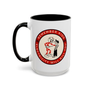 Könnte beinhalten: Eine weiße Keramiktasse mit schwarzem Henkel und schwarzem Rand. Die Tasse zeigt einen roten Kreis mit dem Text "Remember Kids Electricity Will Kill You" und ein Cartoon-Bild eines Mannes in einem roten Anzug, der ein Messer hält, und eines Jungen.