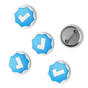 May include: Four blue and white star-shaped buttons with a white checkmark and letter L on them. One button is a blank back for the buttons.
