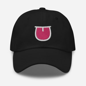 May include: A black baseball cap with a pink tongue emoji embroidered on the front.