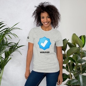 May include: A heather grey t-shirt with a blue star and checkmark graphic. The text "VERIFIED" is printed below the graphic.