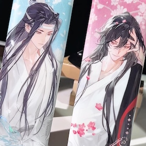 May include: Two phone cases with anime-style illustrations. One case has a light blue background with a character in white robes. The other case has a pink background with a character in white robes and red accents. Both cases feature long-haired characters.
