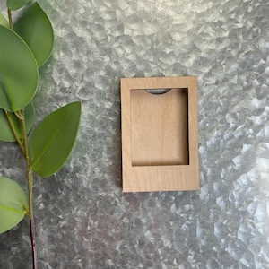 May include: A wooden picture frame with a natural wood finish. The frame has a rectangular shape and a simple design.
