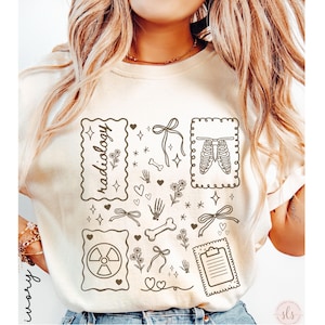 Puede incluir: Camiseta de color marfil con ilustraciones de tem&aacute;tica m&eacute;dica. El dise&ntilde;o incluye la palabra "radiolog&iacute;a" en un marco decorativo, junto con im&aacute;genes de huesos, una caja tor&aacute;cica, un s&iacute;mbolo de radiaci&oacute;n, lazos, corazones y una carpeta. La camiseta tiene cuello redondo.