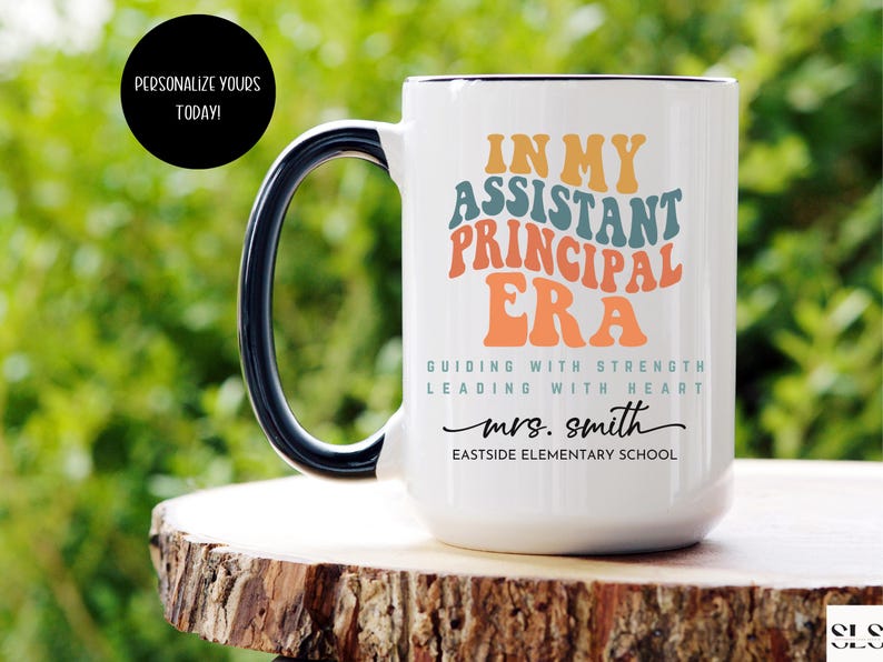 May include: White ceramic coffee mug with a black handle. The mug has a colorful graphic that says "In My Assistant Principal Era" with the text "Guiding with Strength Leading with Heart" and "mrs. smith Eastside Elementary School".