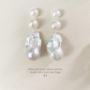 May include: A selection of white pearls, comprising four small, round pearls and two large, uniquely shaped pearls. The pearls are displayed on a light-toned surface. Text on the image reads: "Selected from these pearls, made into your earrings #2."
