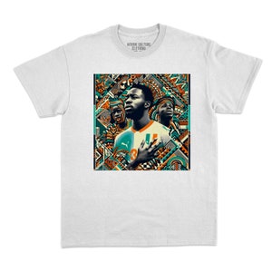 May include: White t-shirt with a vibrant graphic of three figures set against a detailed geometric pattern. The design incorporates orange, teal, and black colours. The collar of the shirt displays the text "AFRIK CULTURE CLOTHING".