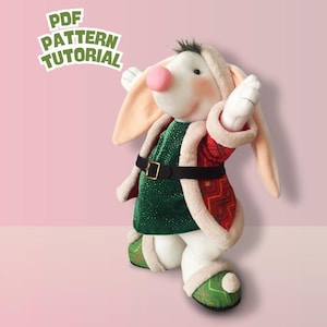 Puede incluir: Un muñeco de peluche de conejo con un atuendo verde y rojo con un cinturón negro. El conejo tiene orejas largas, una nariz rosa y guantes blancos. El texto "PDF PATTERN TUTORIAL" está en la esquina superior izquierda.