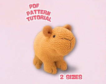 May include: A tan-coloured plush toy animal with a textured surface, small ears and a stitched face. The image includes text that reads "PDF PATTERN TUTORIAL" and "2 SIZES" in a pink and white design.