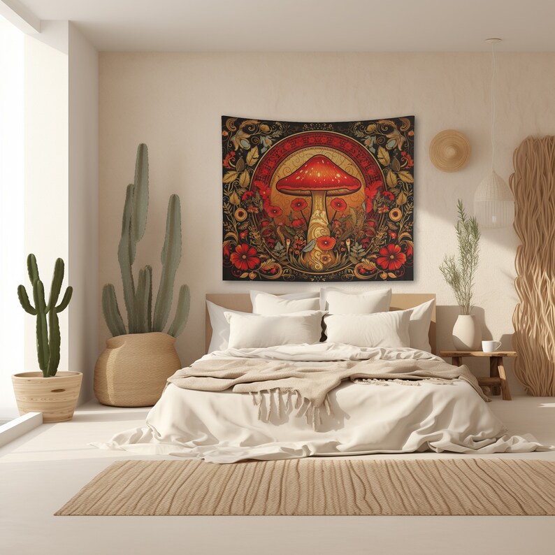 Pu&ograve; includere: Un arazzo con un fungo rosso e bianco con un design floreale dorato e nero. L'arazzo &egrave; appeso a una parete di una camera da letto con un letto bianco e una pianta di cactus.