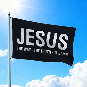 May include: A black flag with the word "JESUS" in large white capital letters. Below, smaller white text reads "THE WAY • THE TRUTH • THE LIFE." The flag is on a silver pole against a bright blue sky with clouds.