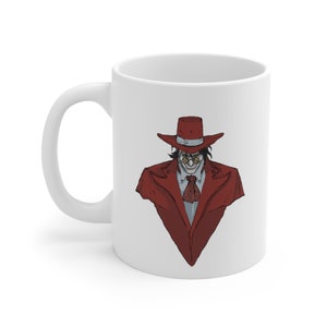 May include: A white ceramic mug featuring a graphic illustration of a character wearing a red wide-brimmed hat, a matching red coat, a light-colored collared shirt with a dark red cravat, and small round glasses, displaying a wide, toothy grin.
