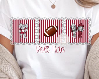 Op de afbeelding: Wit T-shirt met een ontwerp met een olifant, een voetbal en linten. Het ontwerp is geplaatst tegen een rood-witte gestreepte achtergrond. De woorden "Roll Tide" zijn in een cursief lettertype onder het ontwerp geschreven.