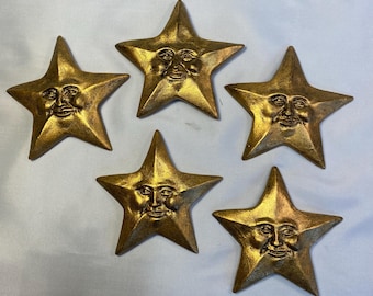 Set of 5 golden stars wall art each one is hand cast, finished and painted. there’s a hole in the back to hang from.