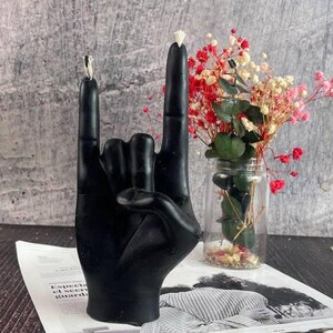 Black wax candle illuminating a dark, stylish room