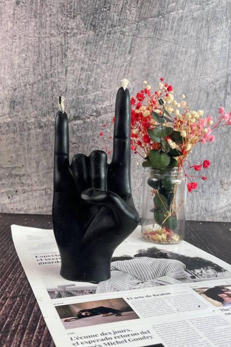 Black wax candle illuminating a dark, stylish room