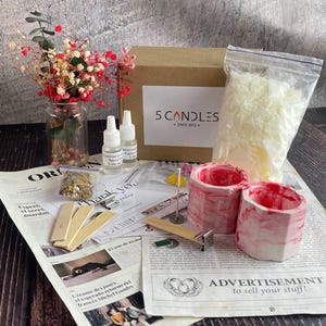Candle jar filled with soft pink soy wax and floral topping in natural daylight