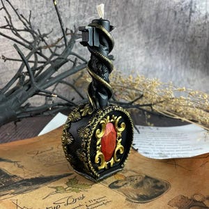 Candle placed on magical parchment with dry twigs and esoteric background props