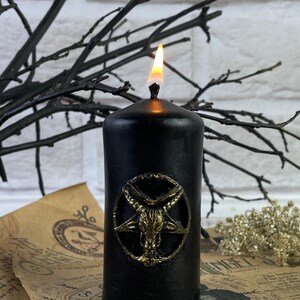Candle next to other witchcraft supplies like crystals, herbs, and incense