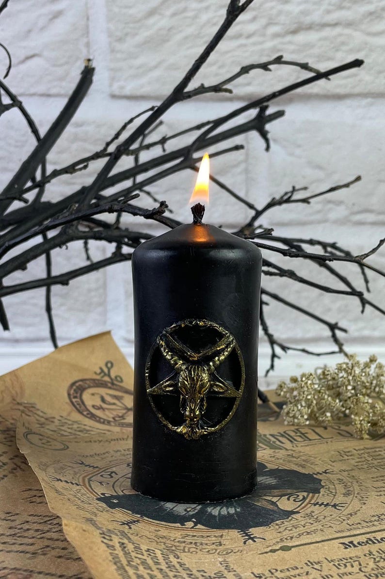 Candle next to other witchcraft supplies like crystals, herbs, and incense