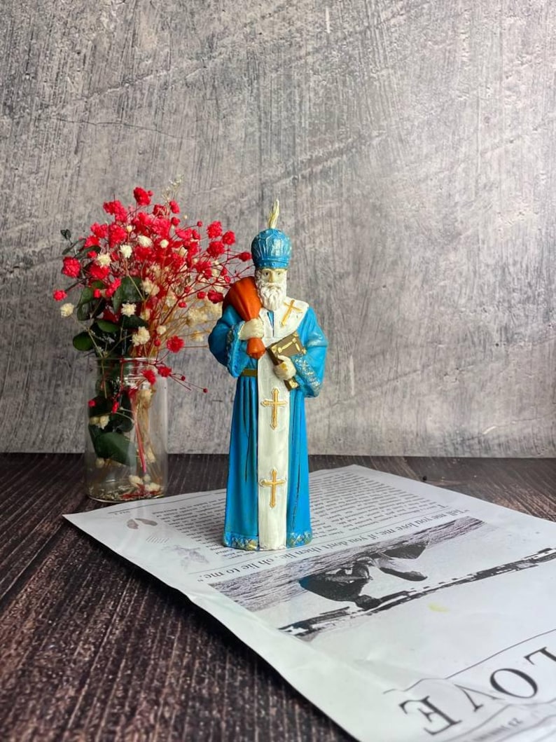 Eco-friendly yellow beeswax candle featuring Saint Nicholas design for holiday gifts