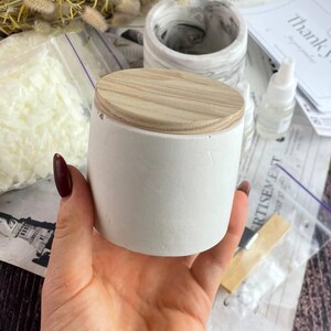 Close-up of a marble-effect candle jar with wooden lid for DIY candle kit.
