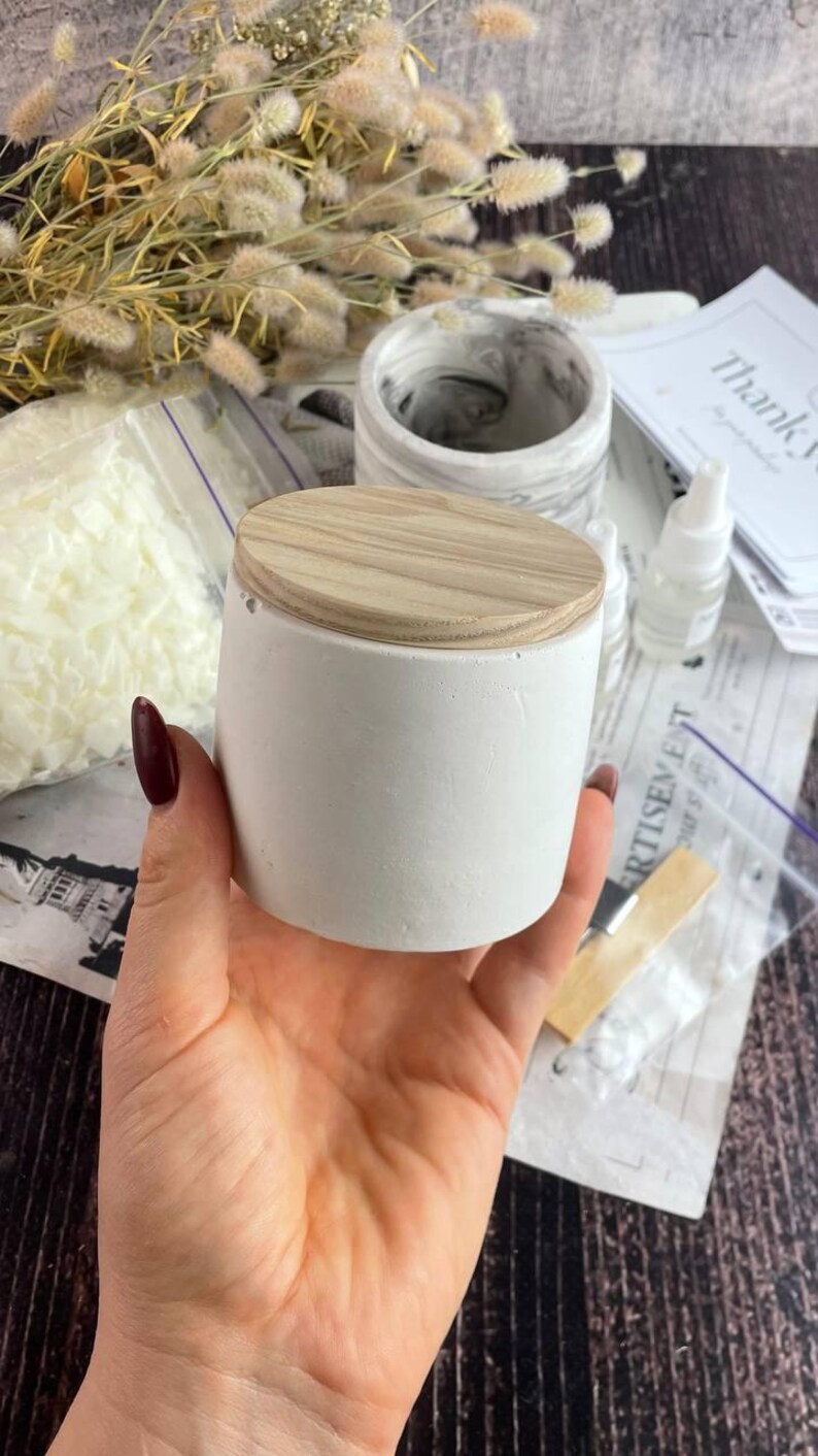 Close-up of a marble-effect candle jar with wooden lid for DIY candle kit.