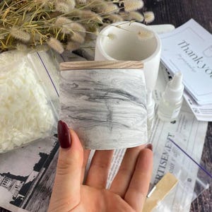 Modern marble candle container with natural wooden lid for handmade candles.