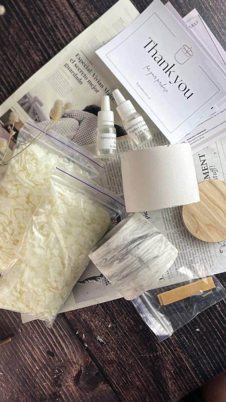 Flat lay of eco-friendly soy wax flakes, oils, and marble jars for candle crafting.