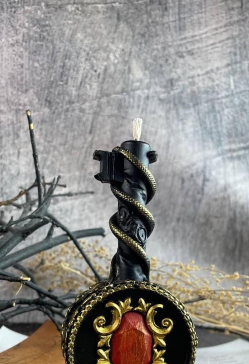 Close-up of the black candle’s detailed serpent design wrapping the vertical handle
