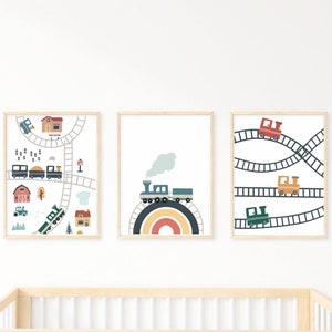 May include: Three framed prints with a train theme. The first print shows a train track with a train traveling through a town with houses, trees, and a red barn. The second print shows a train traveling over a rainbow. The third print shows a train track with three trains traveling on it.