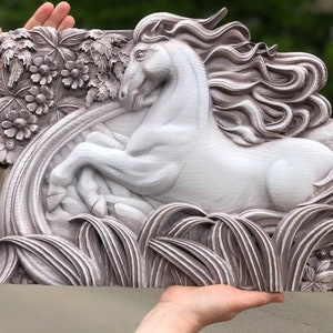 May include: A white wooden sculpture of a horse with a flowing mane, set against a background of carved flowers and leaves. The sculpture is painted in a light brown colour and has a distressed finish.