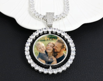 May include: A silver chain necklace with a round pendant featuring a photo of a family. The pendant is surrounded by a circle of clear cubic zirconia stones.