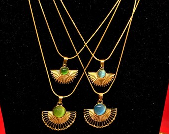 May include: Three gold chain necklaces with a fan-shaped pendant featuring a green, blue, and light green stone.
