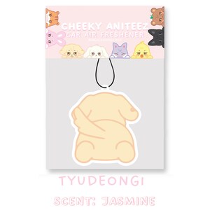 May include: A yellow car air freshener shaped like a dog with its tail curled around its body. The text "CHEEKY ANITEEZ CAR AIR FRESHENER" is at the top of the image. The text "TYUDEONGI SCENT: JASMINE" is at the bottom of the image.