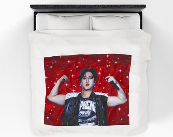 Puede incluir: Una funda nórdica blanca con una imagen vibrante de una persona flexionando los brazos. La persona lleva un chaleco negro sobre una camiseta blanca con la palabra "PREM" impresa. El fondo es rojo con destellos blancos en forma de estrella.