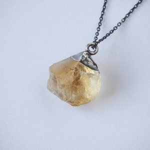Peut inclure: Un collier en chaîne argent avec un pendentif en cristal de citrine brut jaune.