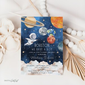 May include: A blue and white baby shower invitation with a watercolor illustration of an astronaut holding balloons shaped like planets. The text reads "Houston, We Have A Boy" and includes the name "Madison Roberts".
