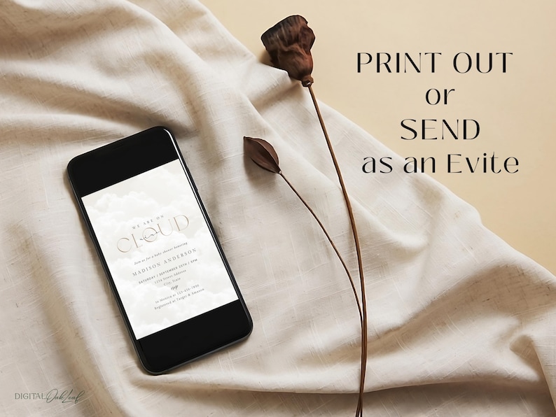 May include: A digital invitation on a smartphone screen with a white background and the text "We are on a Cloud" and "Madison Anderson". The text is in a modern, minimalist font. The phone is lying on a beige fabric surface with dried flowers.