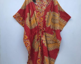 Puede incluir: Una kaftán roja y dorada con estampado y cintura con cordón. La kaftán tiene cuello en V y mangas cortas.